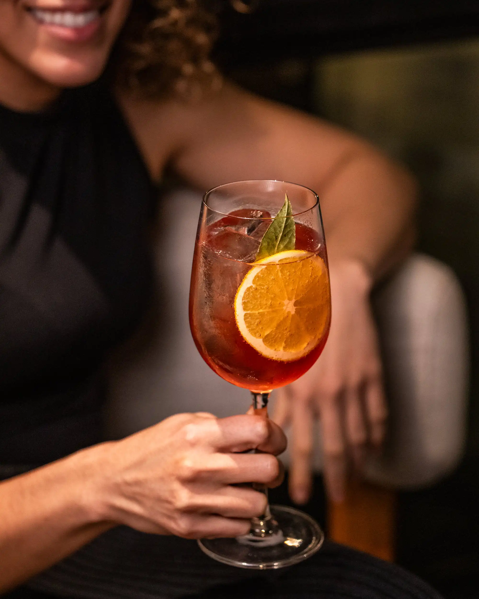 Women holding a citrus cocktail at Juniper