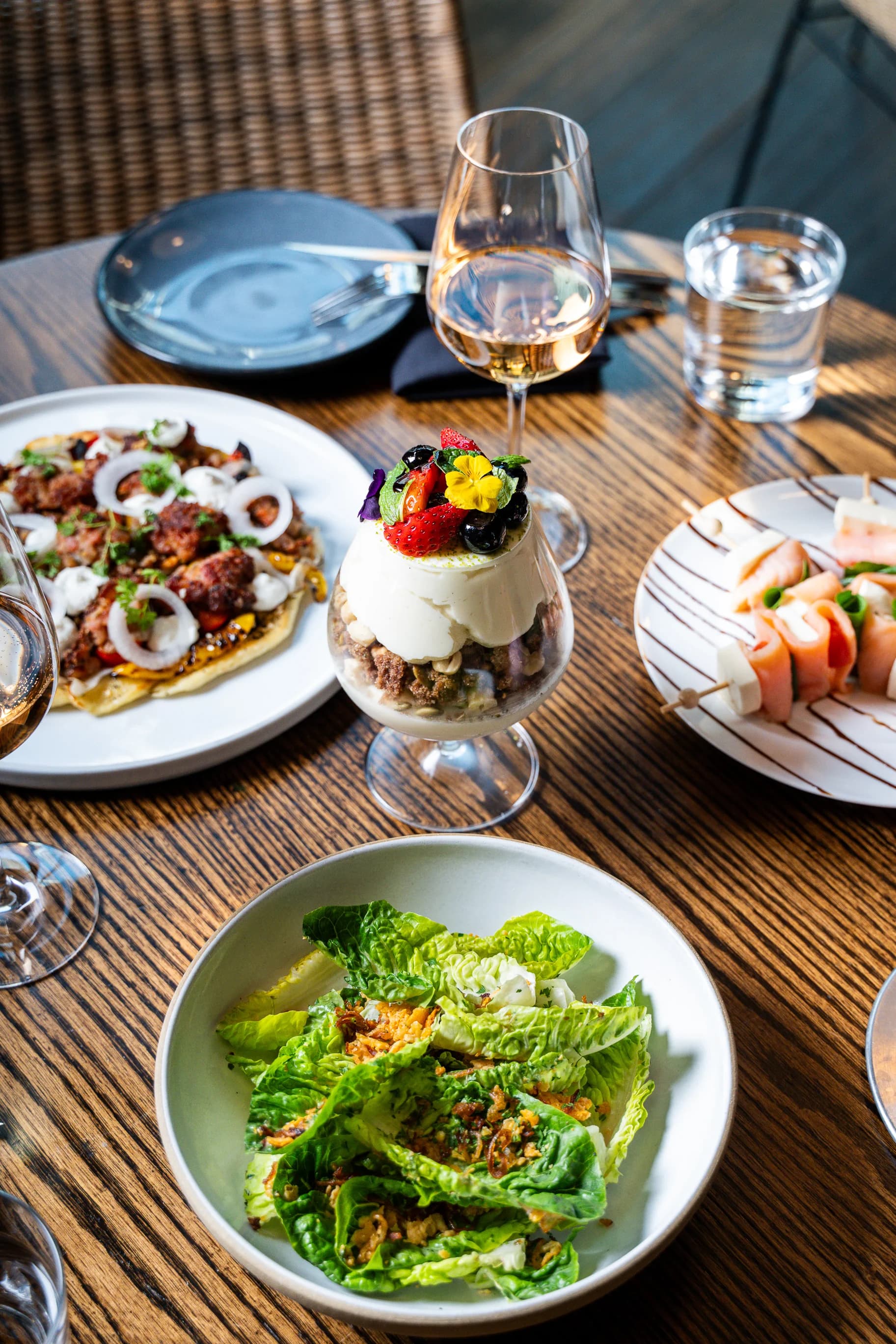 Brunch table with wine, panna cotta parfait, salads and shared plates