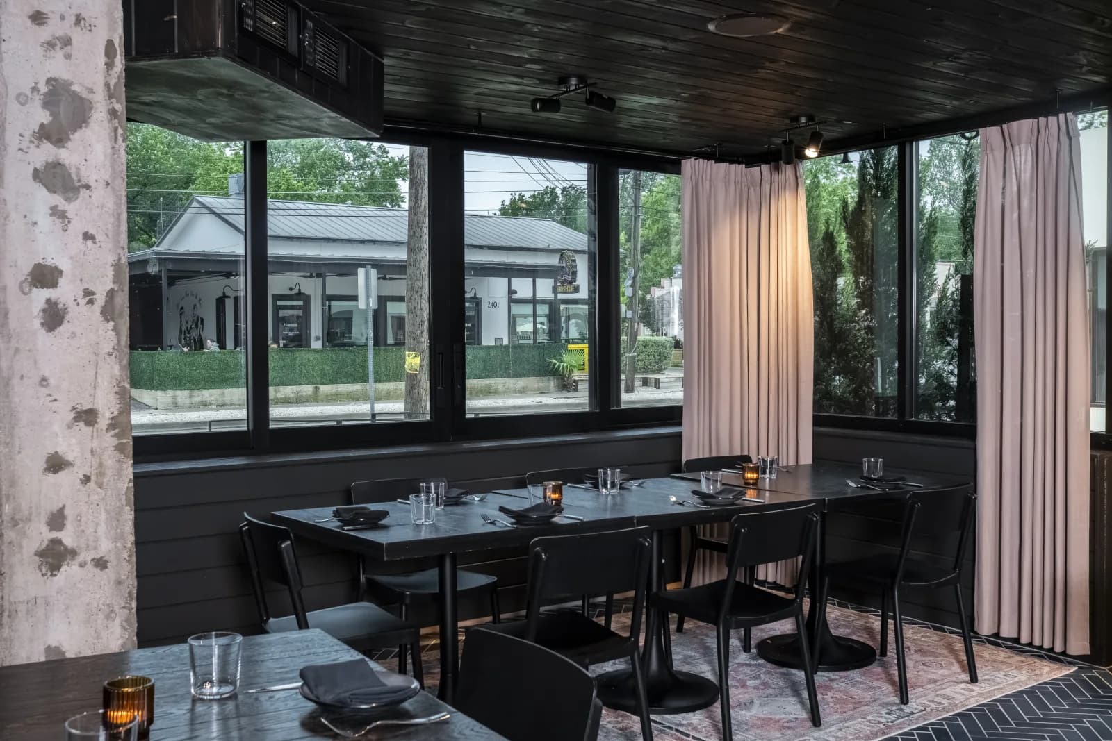 Corner table by the windows overlooking the East Austin street at dusk