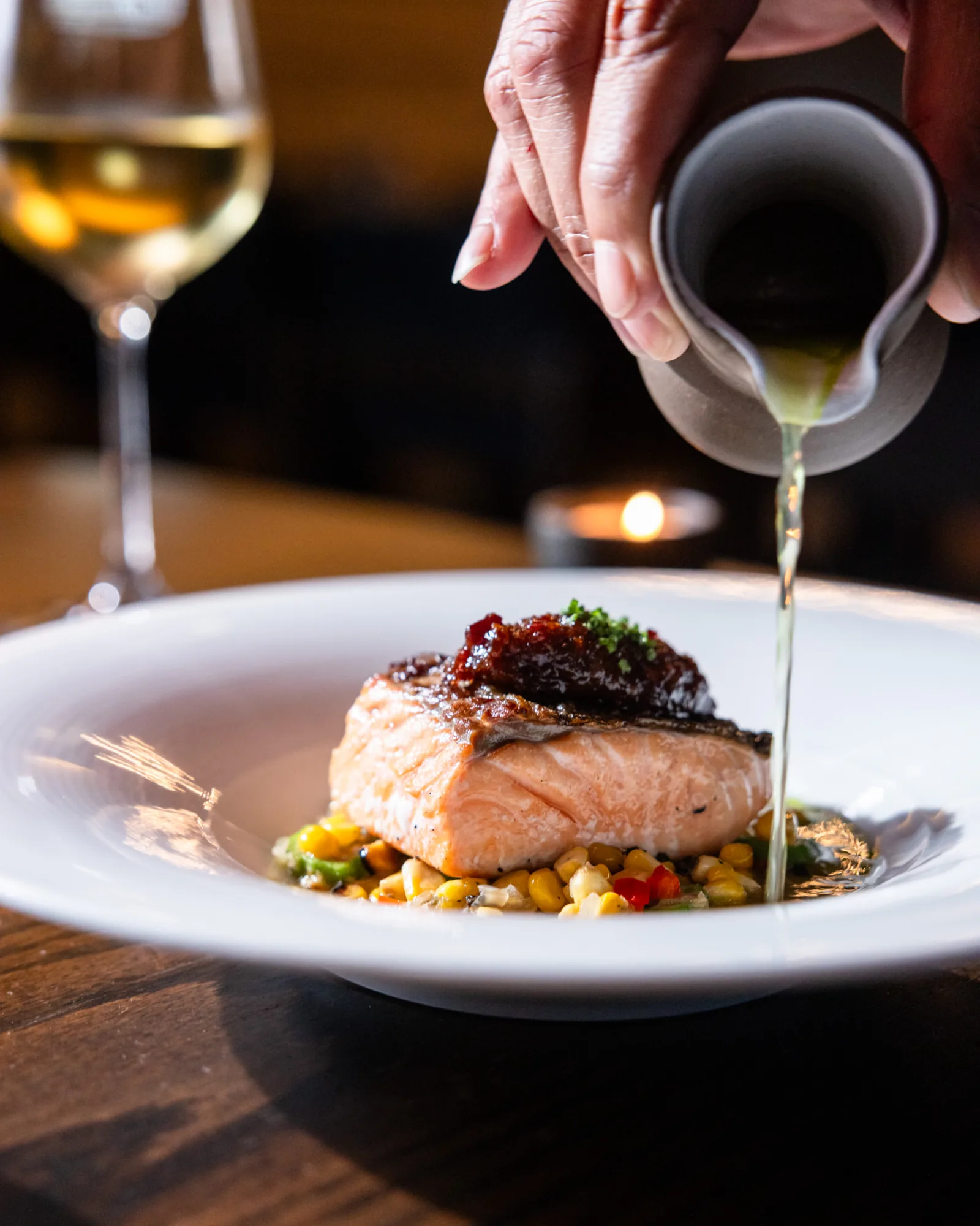 Grilled fish over succotash with broth poured at the table at Juniper